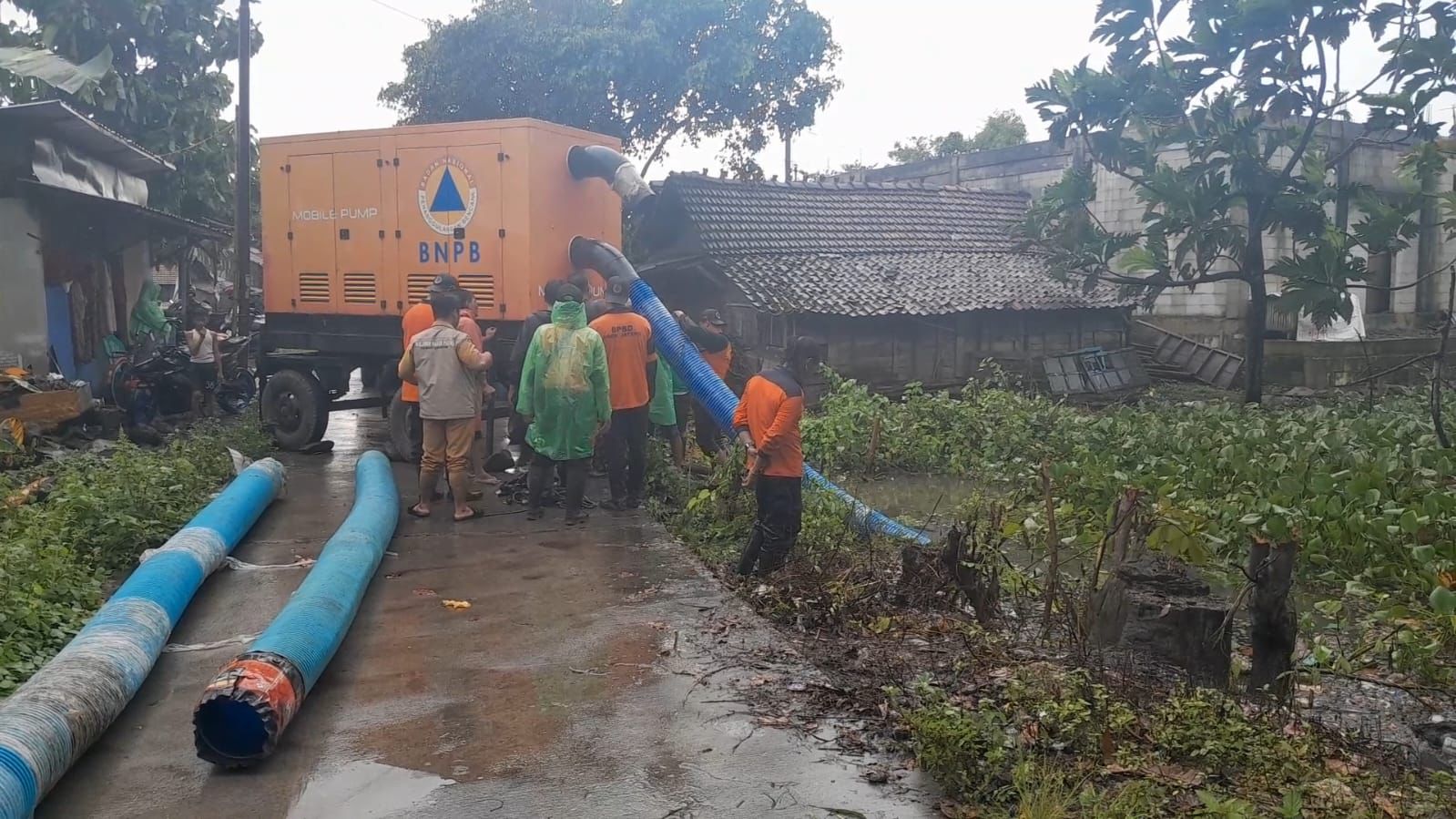 Personel TRC BPBD Kabupaten Demak saat mengoperasikan Mobile Pump untuk menyedot genangan air di kawasan pemukiman Desa Kalisari, Kecamatan Sayung, Rabu (14/1/2026).